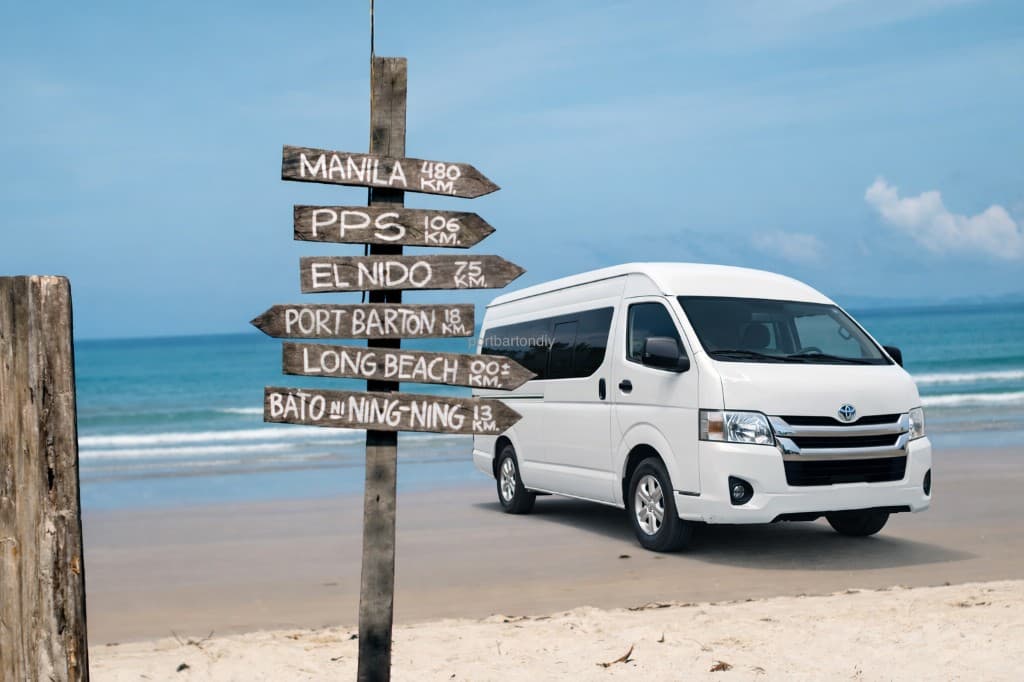 Van on the beach next to a signpost showing distances to El Nido and Port Barton
